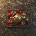 Top-down flat lay of luxury Arabic Dallah and Finjan coffee set with dates and cardamom on marble tray