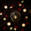 Top-down flat lay of luxury Arabic lantern with rose petals and candles on dark velvet